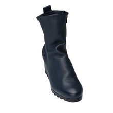 Embrace the comfort of the wedge with this mid-calf style boot available in calf skin leather or nubuck. Featuring a fashionable crepe sole for extra-grip and style on wet city streets. Inside side zip,  pull-on tab, top stitch feature with a rounded toe. navy